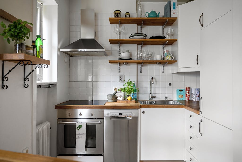 Contemporary small kitchen featuring stainless steel appliances and open shelving.