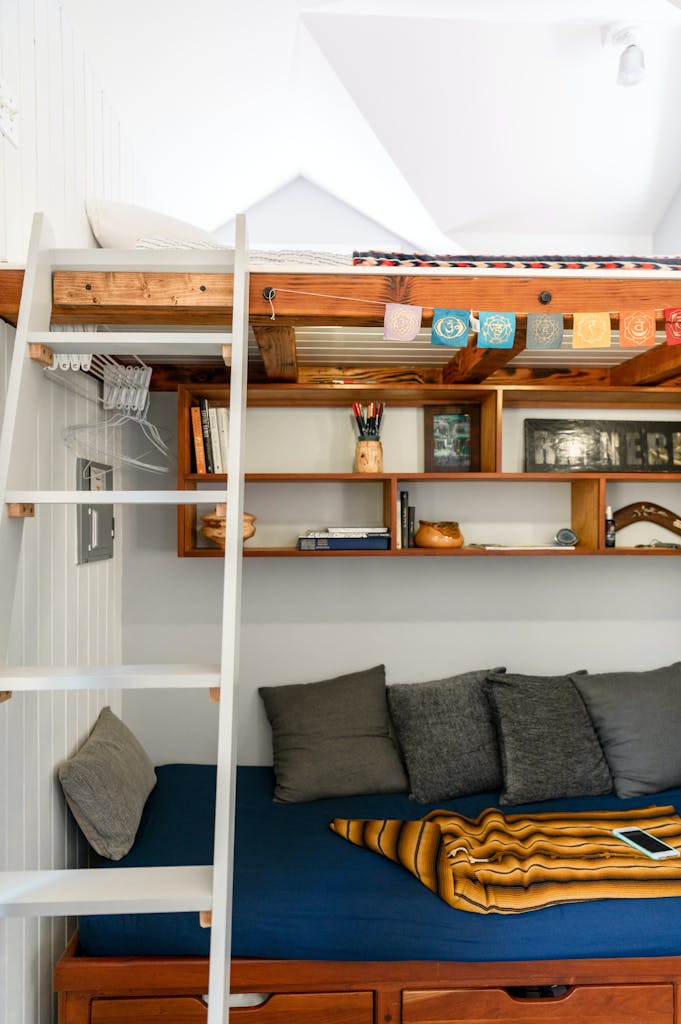 Stylish loft bed setup with a functional ladder and built-in shelving in New York City apartment.