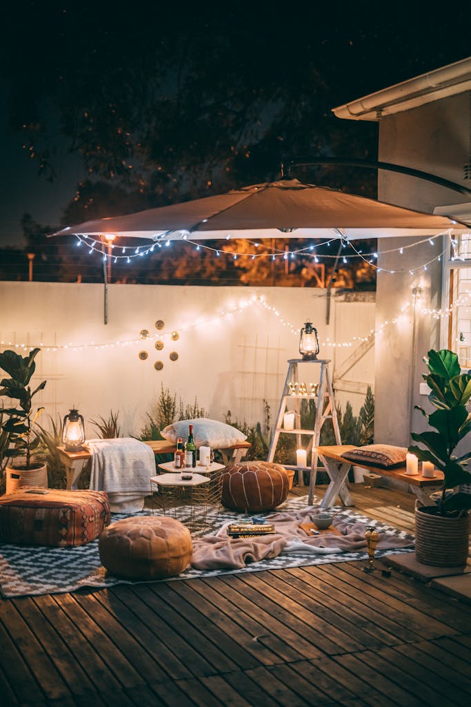 Charming outdoor patio scene with cozy seating and warm lighting at night.